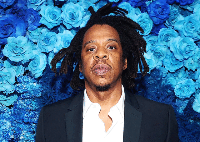 Jay-Z lookalike in suit by blue roses.