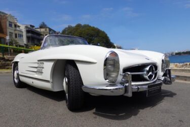 Vintage Mercedes Benz convertible on street.