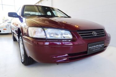 A maroon 1997 Toyota Camry parked indoors.