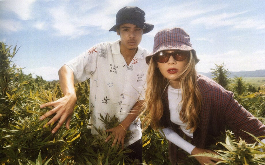 Two people wear Australian menswear in field.