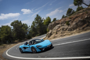 Blue sports car drives through Australia's rocky terrain.