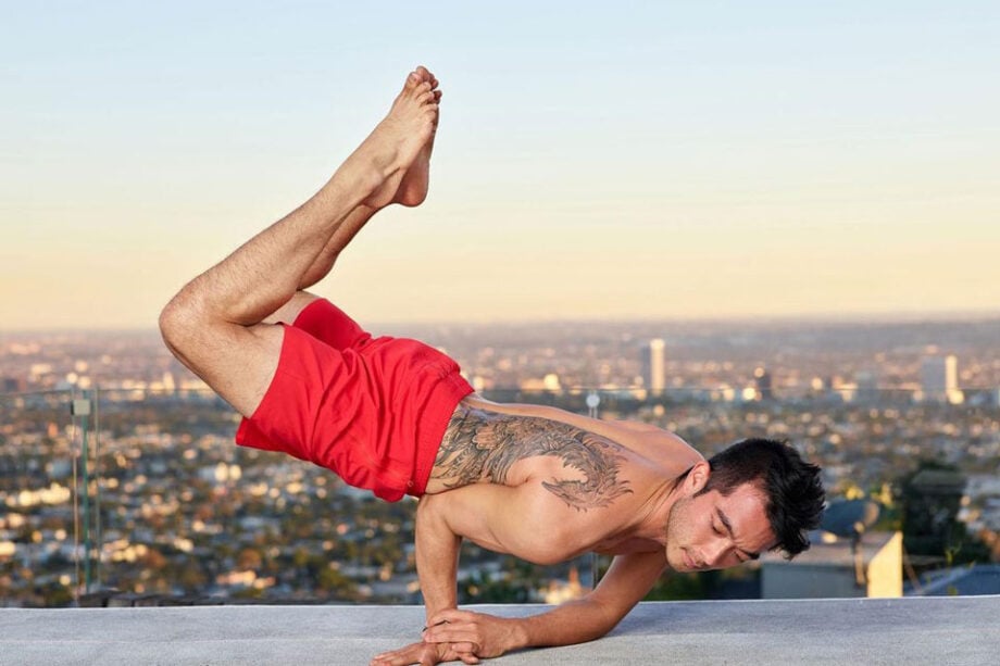 Person in yoga pose wearing branded red shorts.