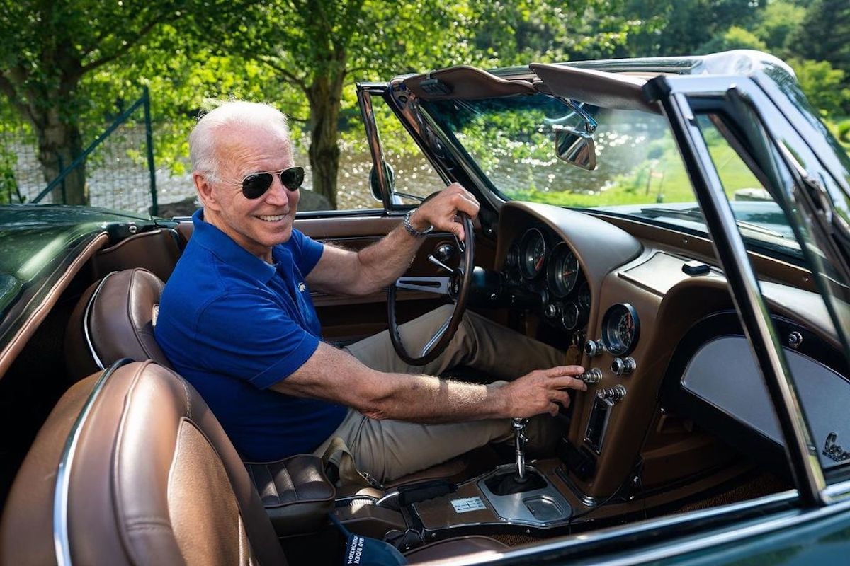 Person in blue sits in classic Corvette.