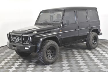 Black Mercedes-Benz G-Class SUV on checkered floor.