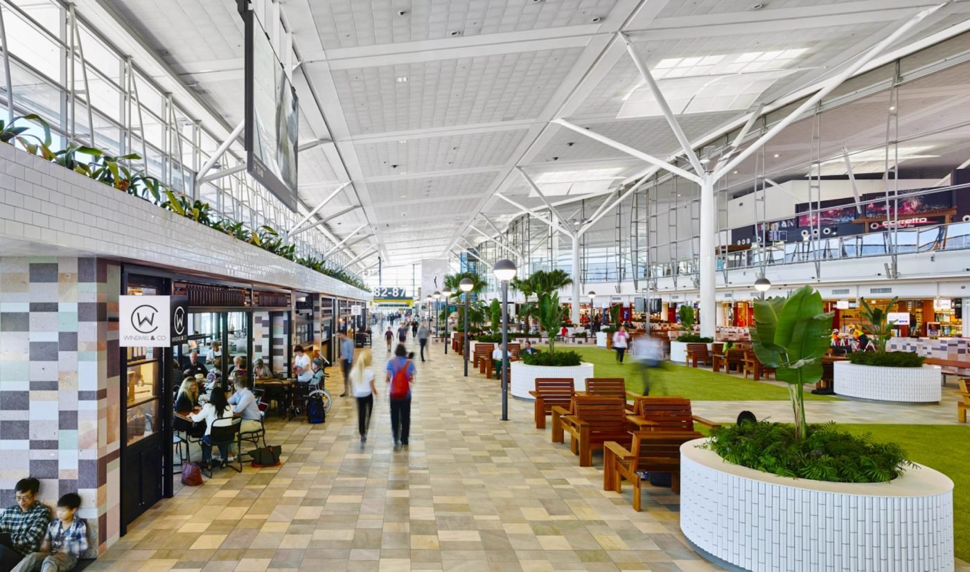 Brisbane Airport's terminal features greenery, cafes, and seating.