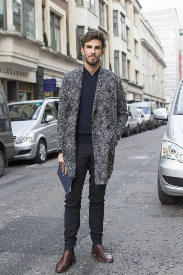 Man in street holding folder.