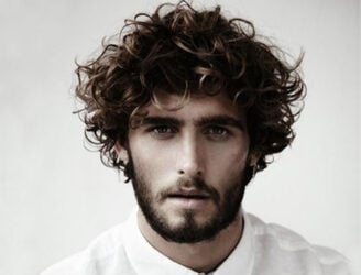 Curly-haired man, beard, white shirt.