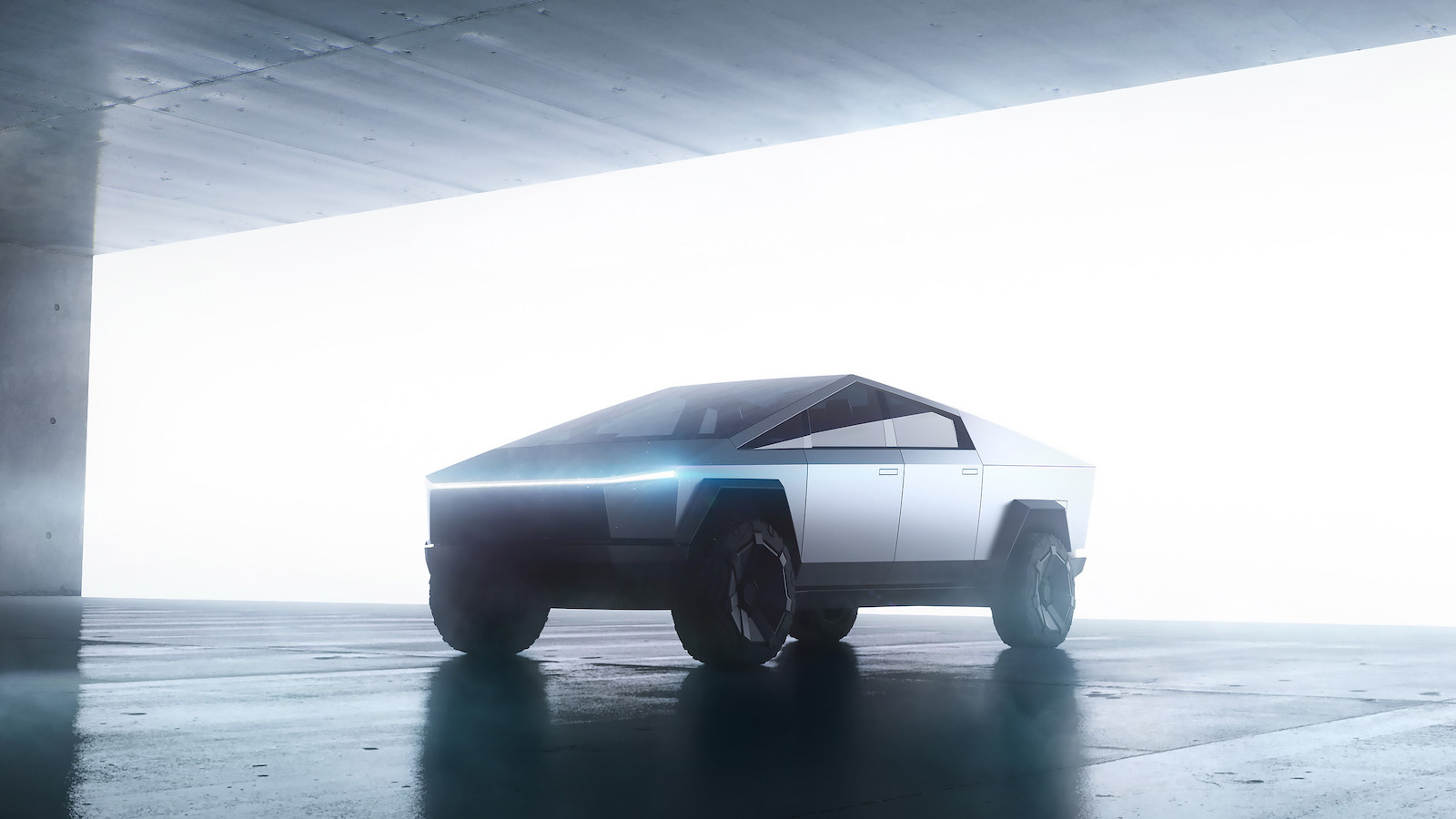 Tesla Cybertruck parked, backlit under concrete structure.