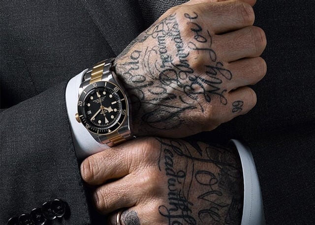 David Beckham's tattooed hands with luxury watch.