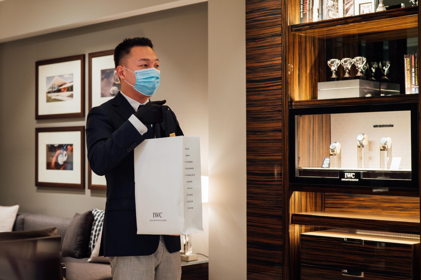 Man in mask holds bag in Sydney boutique.