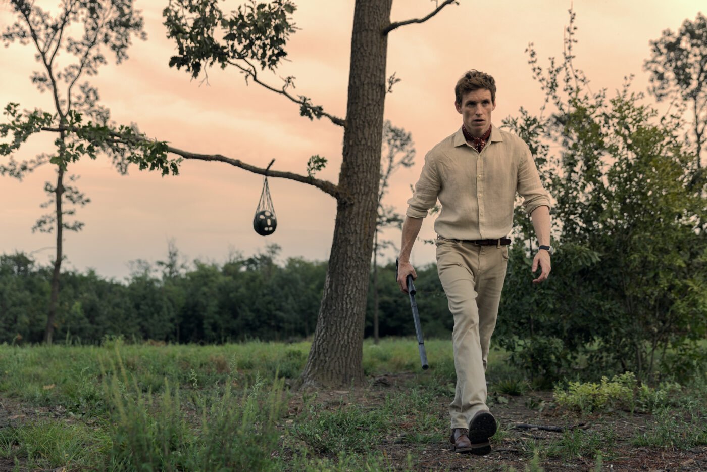 Eddie Redmayne in his Jackaroo look, approaches punching bag at sunset.