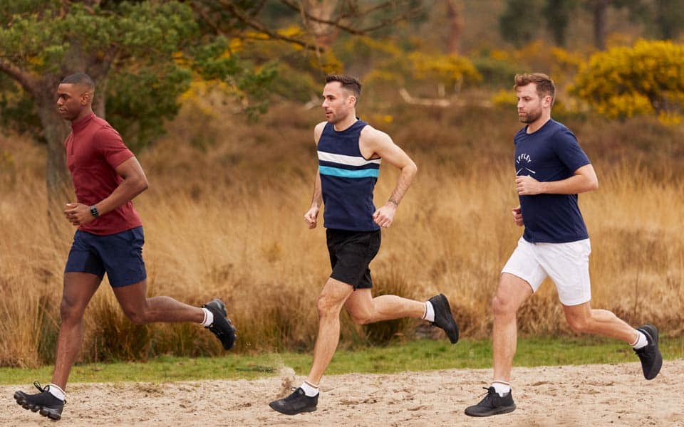 Three men jogging in nature.