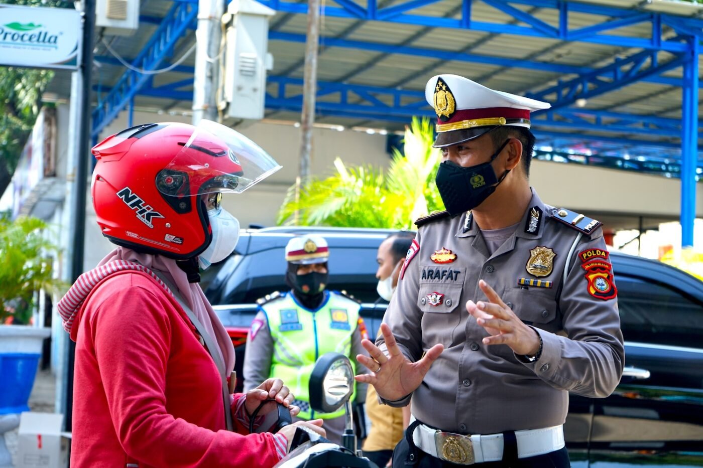 Officer talks to motorcyclist in Indonesia; another nearby.