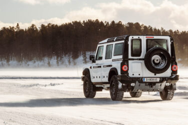 Land Rover Defender navigates snowy landscape confidently.