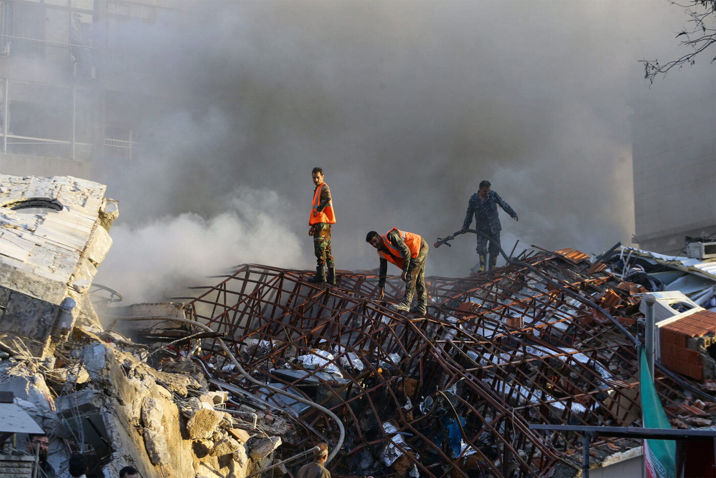 Emergency personnel extinguish a fire at the site of strikes in Syria's capital Damascus after Israeli missiles hit an Iranian consular annex