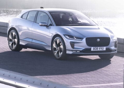 Jaguar I-Pace SUV parked by foggy water.