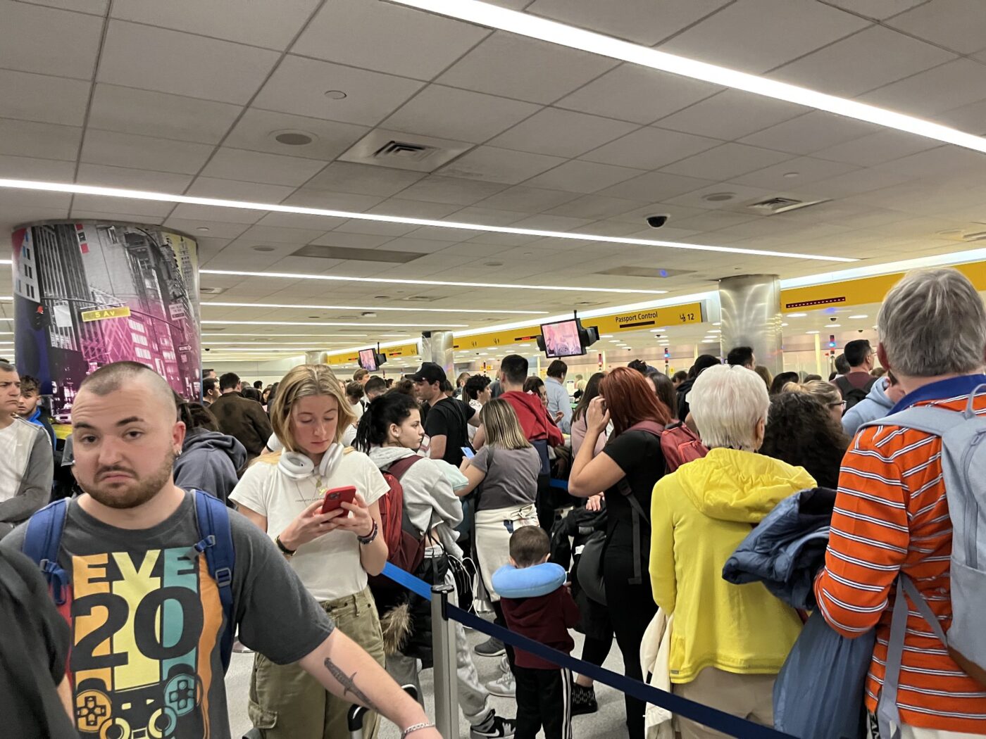 Travellers wait in busy JFK airport terminal.