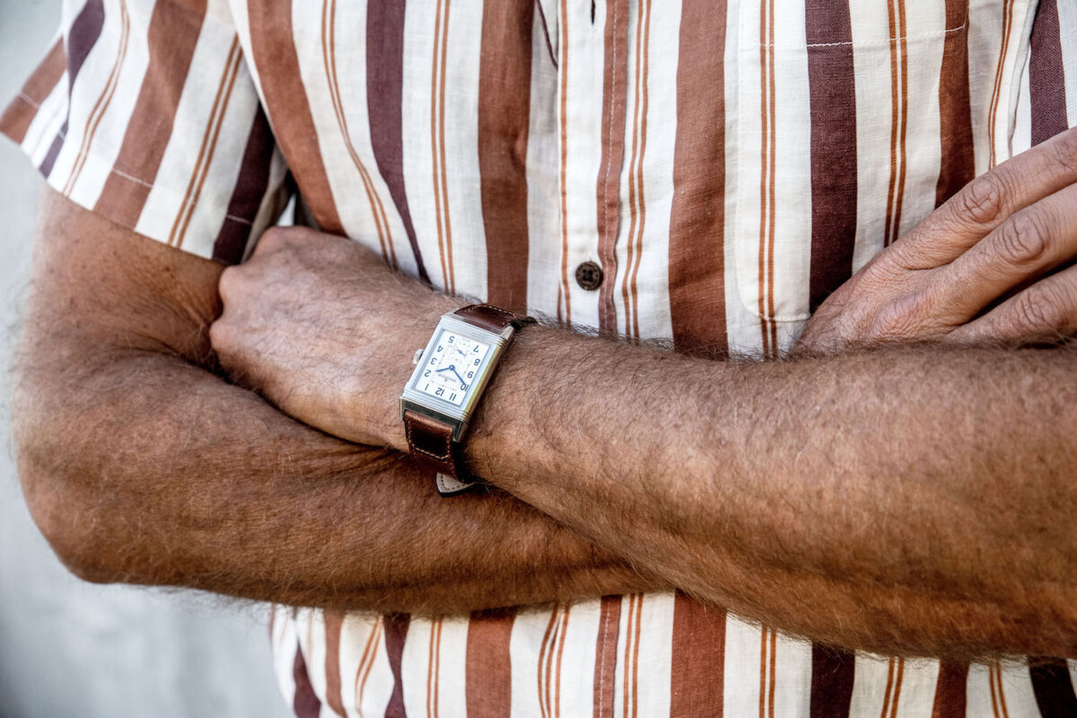 Man showcases Jaeger-LeCoultre Reverso watch.