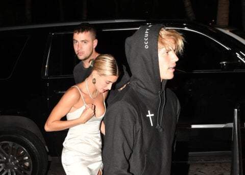 Woman and Justin Bieber lookalike walk at night.