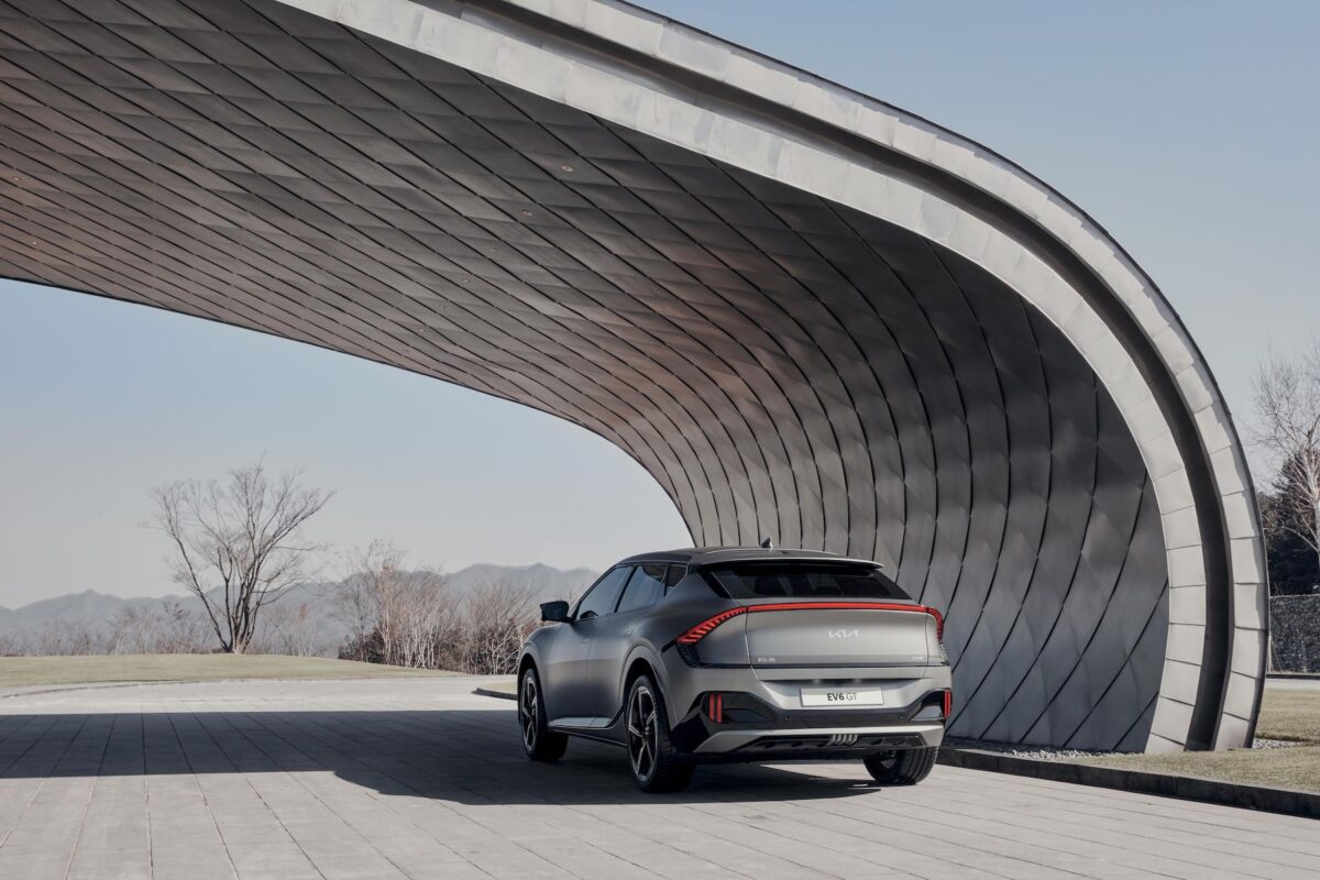 Kia EV6 parked under a curved structure.