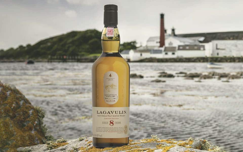 Lagavulin 8 Whisky on a rocky shore.