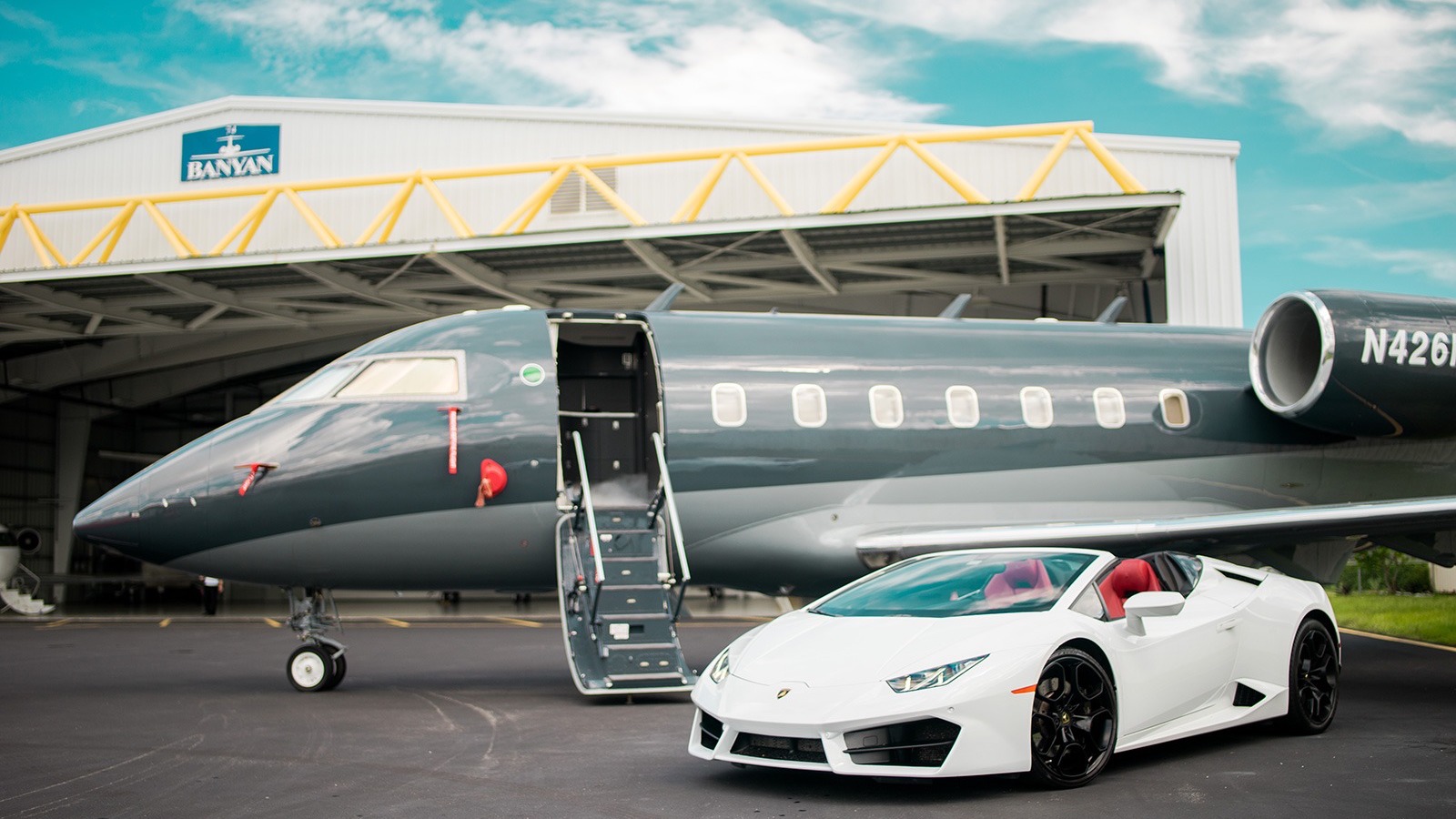 White supercar and Banyan jet on airstrip.