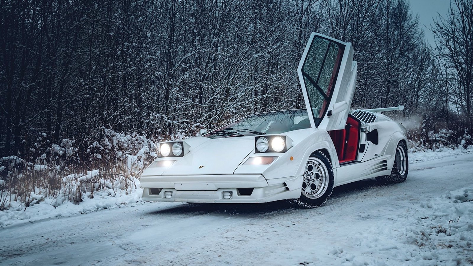 A white sports car with winter tyres.