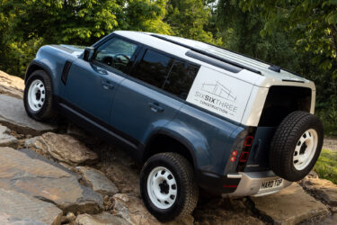 A blue Six Six Three Land Rover navigates rocks.