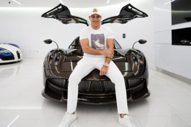 Manny Khoshbin sits on sports car.