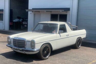 Classic white Mercedes-Benz ute with Toyota backdrop.