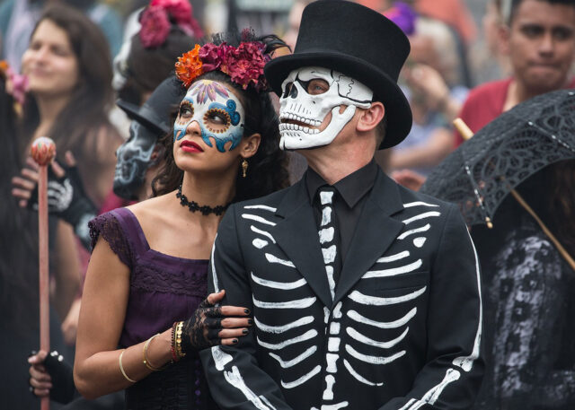 Couple in Day of the Dead costumes celebrate.