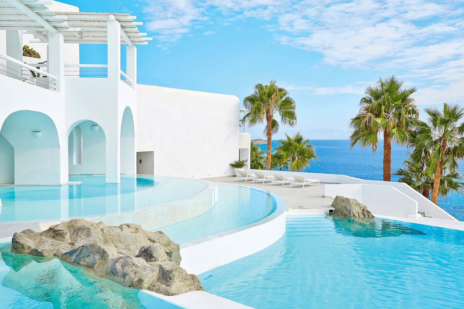 Exclusive seaside resort with infinity pools and palm trees.