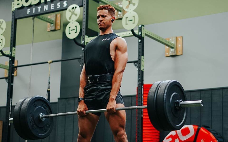 A person lifts weights at a vibrant gym.