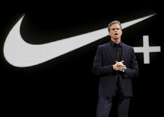 Man speaks on stage before Nike+ logo.