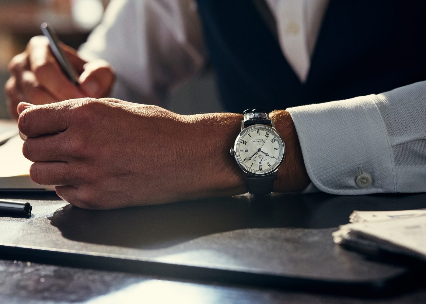 Elegant wristwatch, writing in notebook.