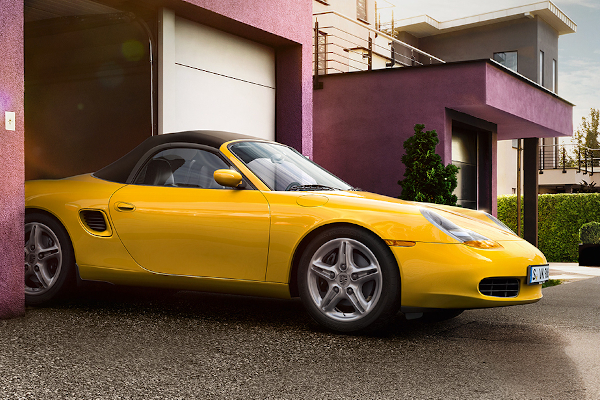 2021 yellow Porsche Boxster partly in magenta garage.