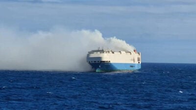 Cargo ship ablaze, Porsches at risk.