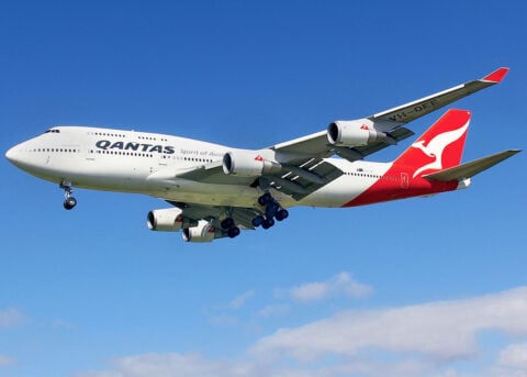 Qantas 747 flying with landing gear down.