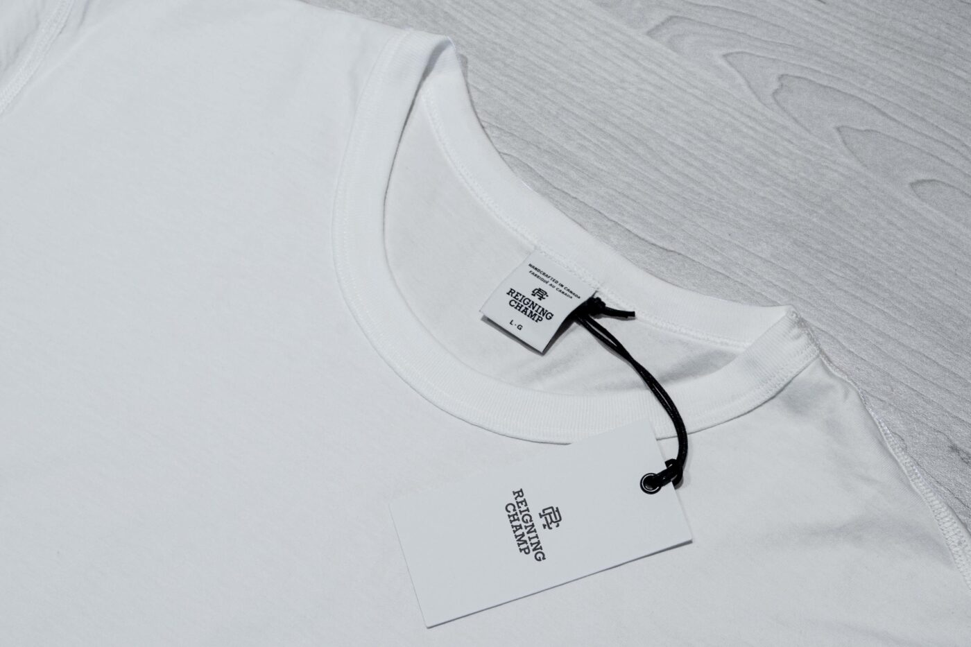 Reigning Champ white tee collar and label close up 