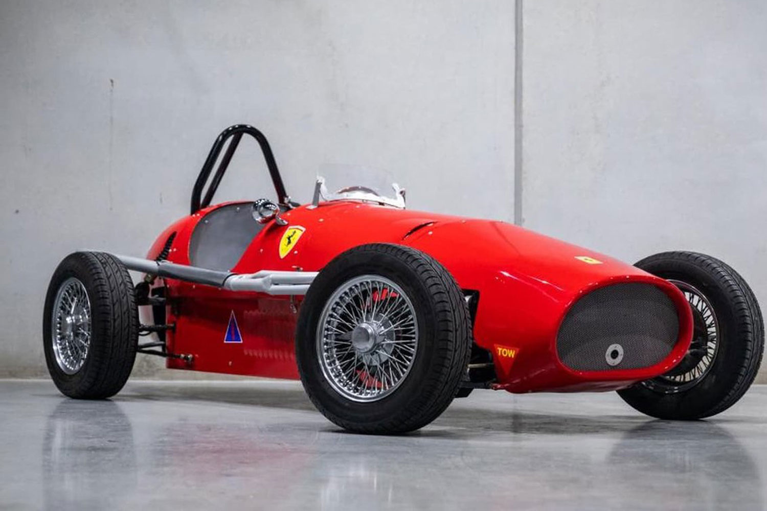 A vintage racing car flaunts prancing horse logo.