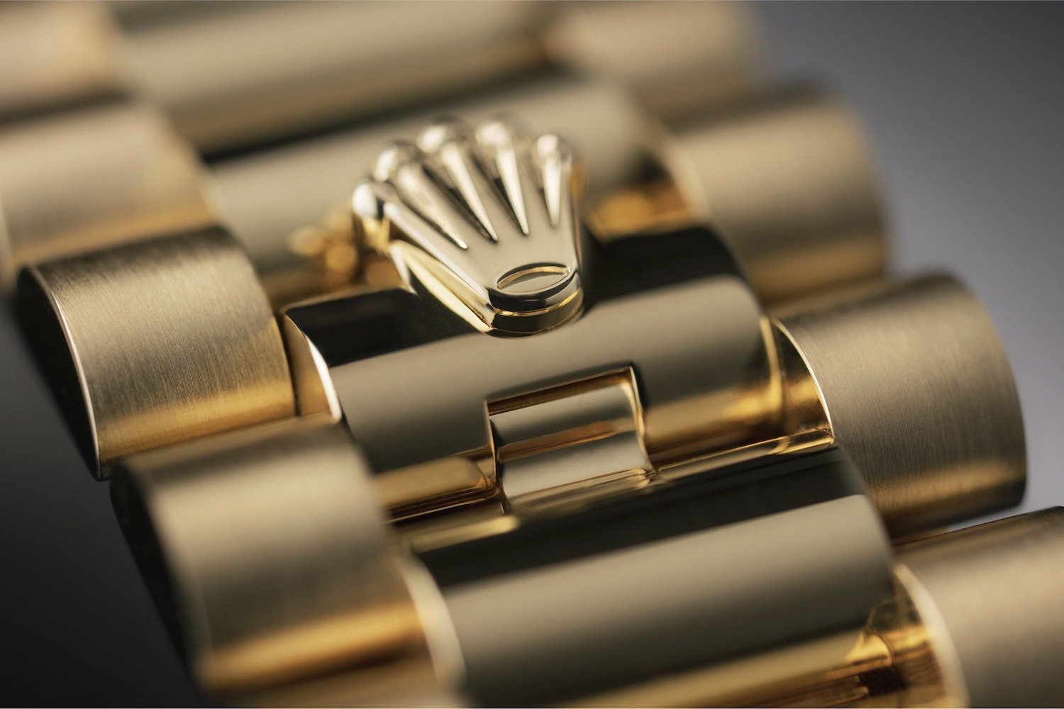 Rolex bracelet: luxury gold with embossed emblem.