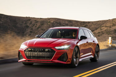 A red Audi wagon travels through Australian hills.