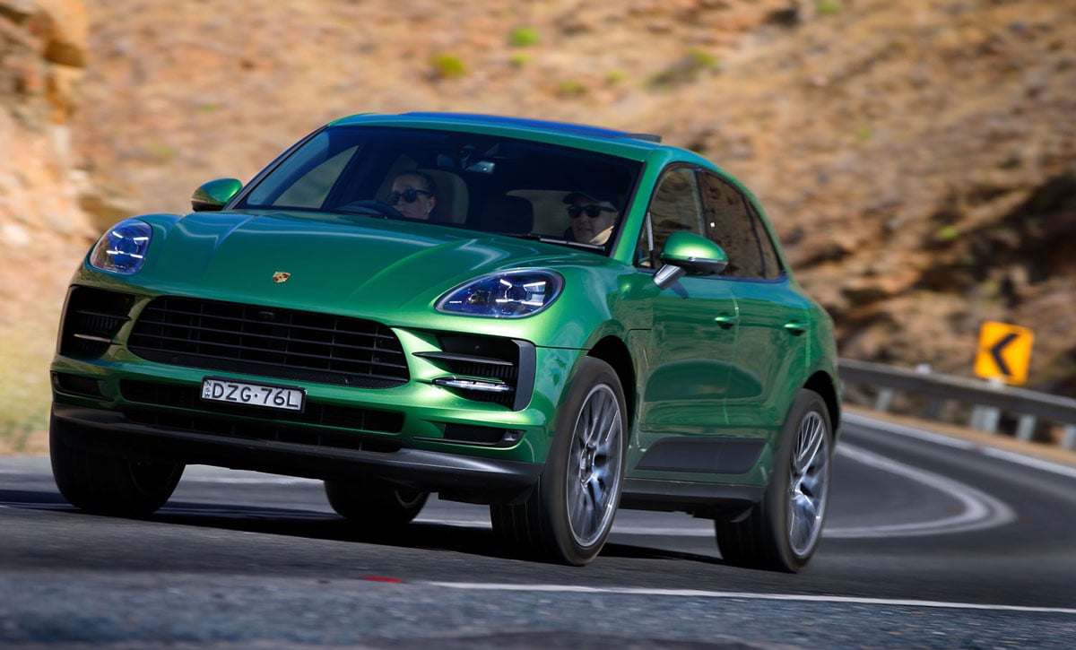 Green Porsche Macan on mountain.