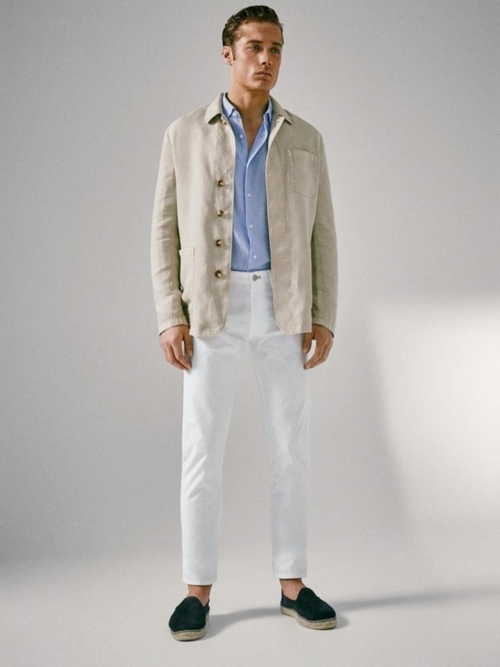 A man wearing light blue long sleeves paired with off white work jacket