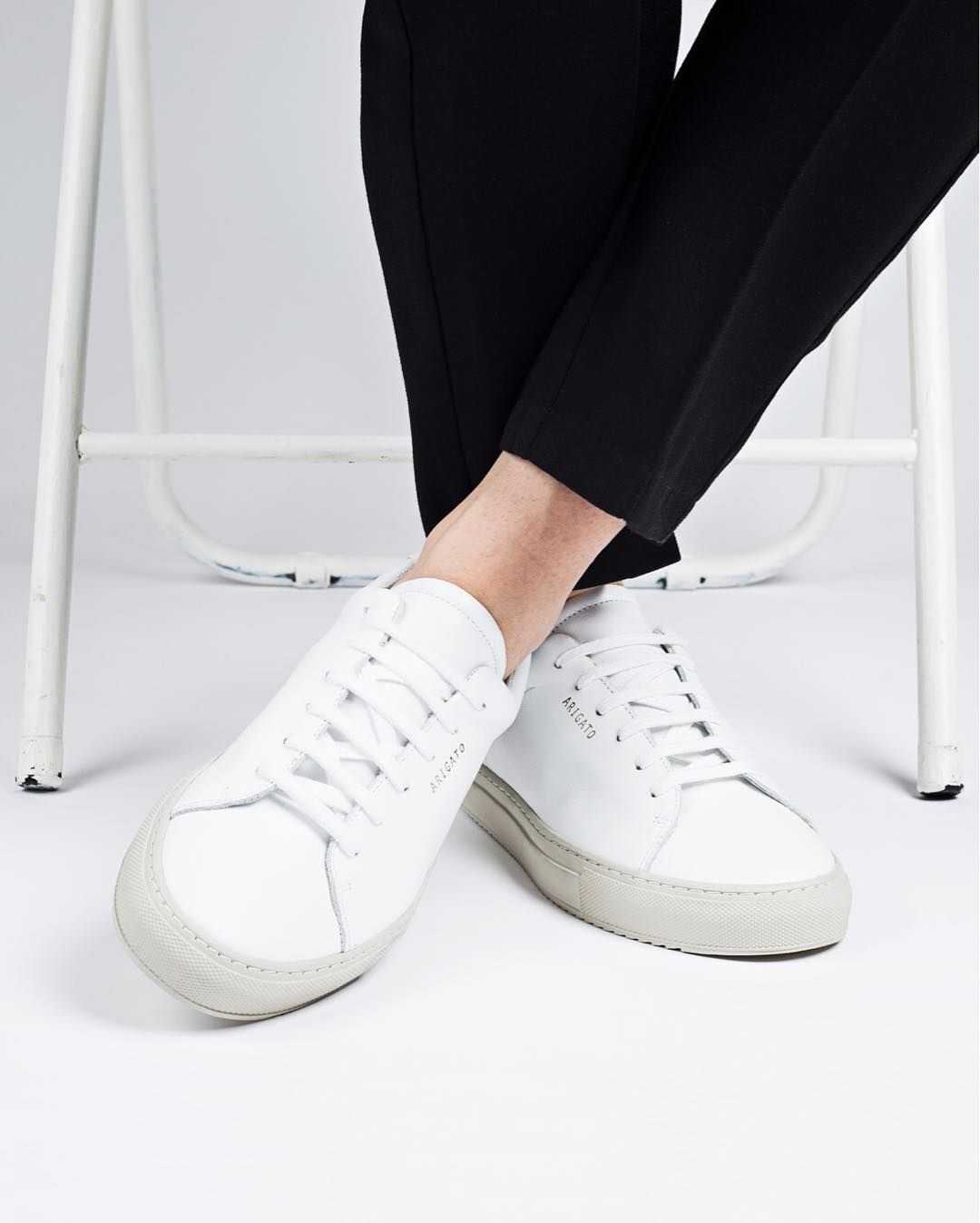 White shoes, black jeans, seated.