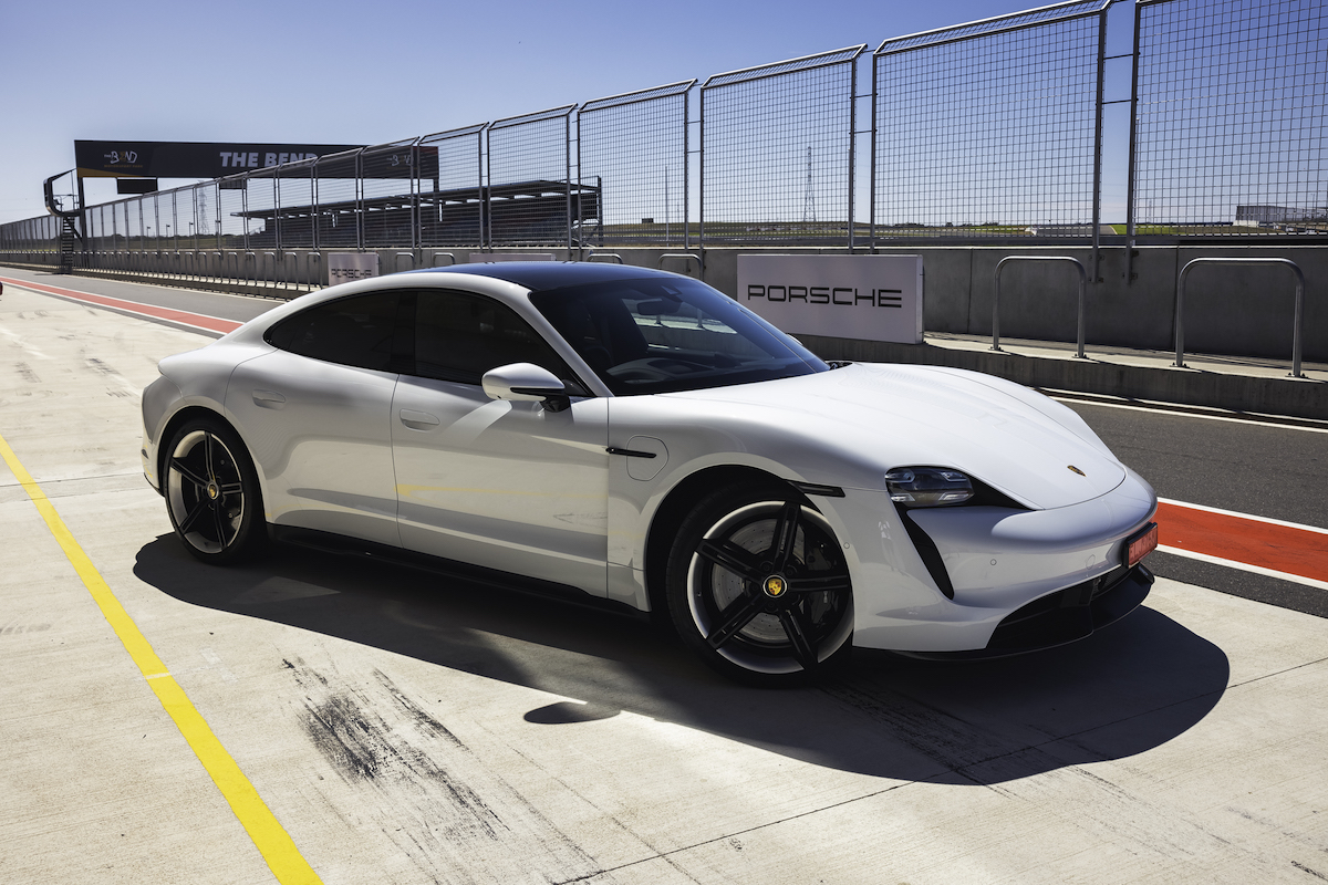 White Porsche Taycan Turbo S on racetrack.