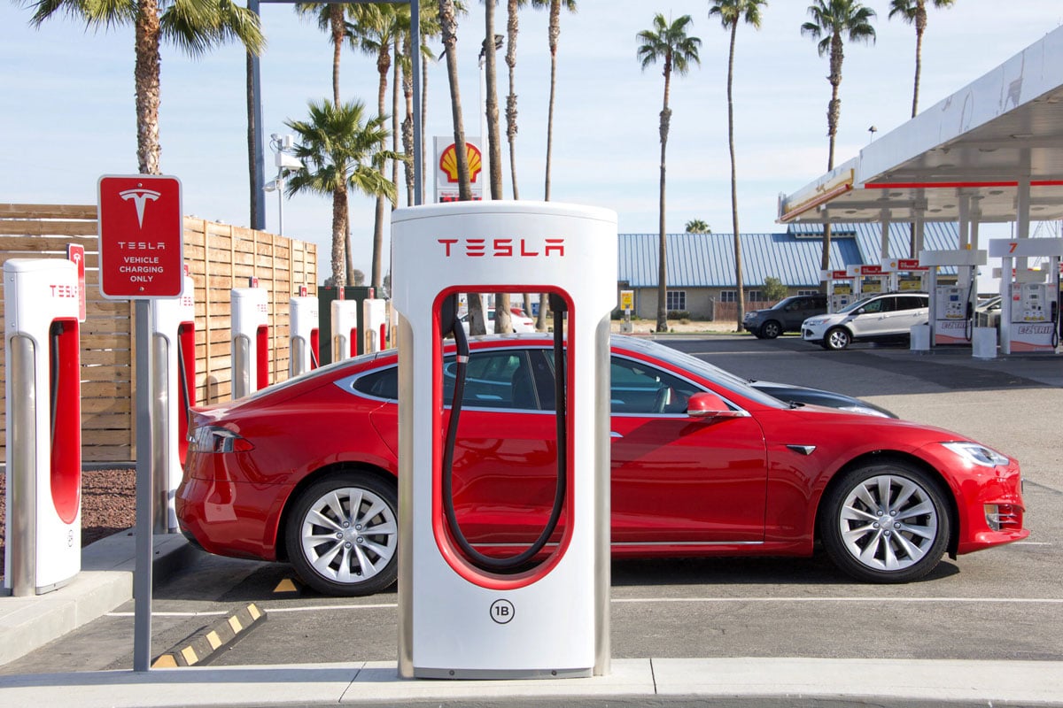 A red Tesla charges in Australian paradise.