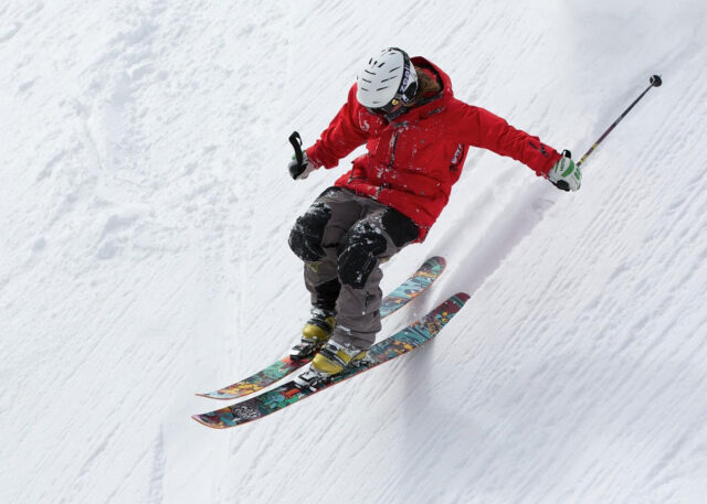 Skier in red jacket enjoys New Zealand slopes.