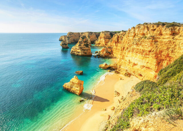 Golden cliffs and blue sea along European beaches.