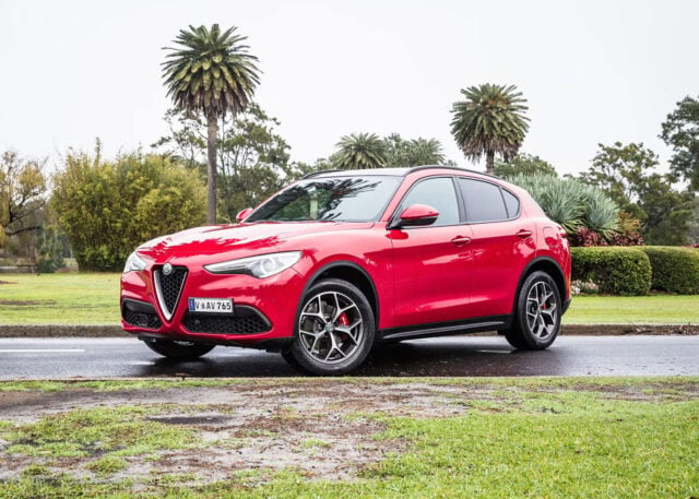 Alfa Romeo Stelvio on wet road, overcast sky.